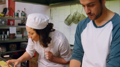 male and female baker putting ingredients on pasta dough 4k