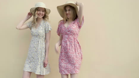 two women in floral dresses and straw hats