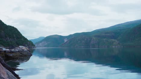 Scenic-Mountain-Range-and-Calm-Waters-Of-Fjord-In-Norway