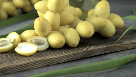 las palmeras de dátiles frescas se colocan en la mesa con aceite, concepto de alimentos saludables. palmeras de dátils. frutas crudas de palmieras de dátiles (phoenix dactylifera)