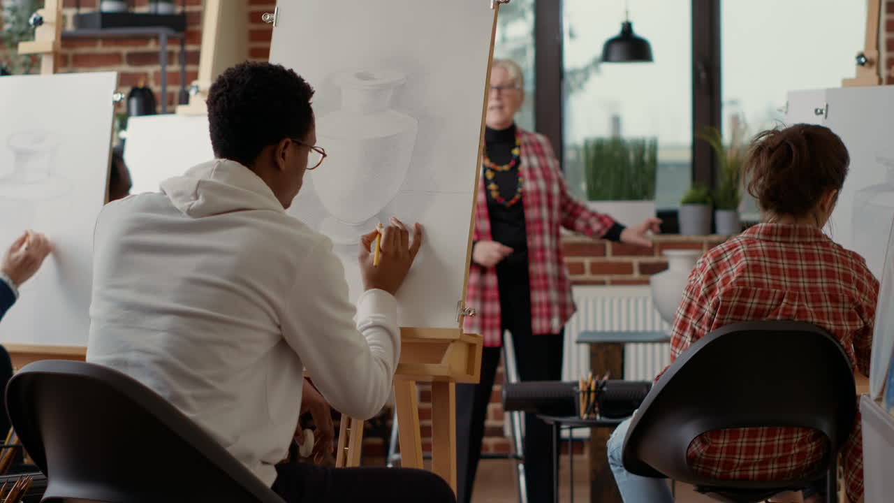 African american student using pencil to draw vase sketch