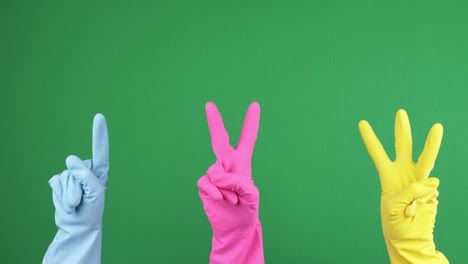 hands counting from 1 to 3. three hands with protective rubber gloves show one, two, three fingers over chroma key green screen background. 4k video