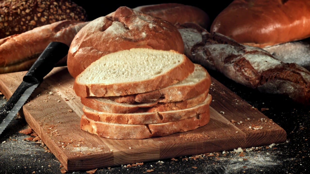 Primo piano di pane fresco affettato su un tagliere di legno