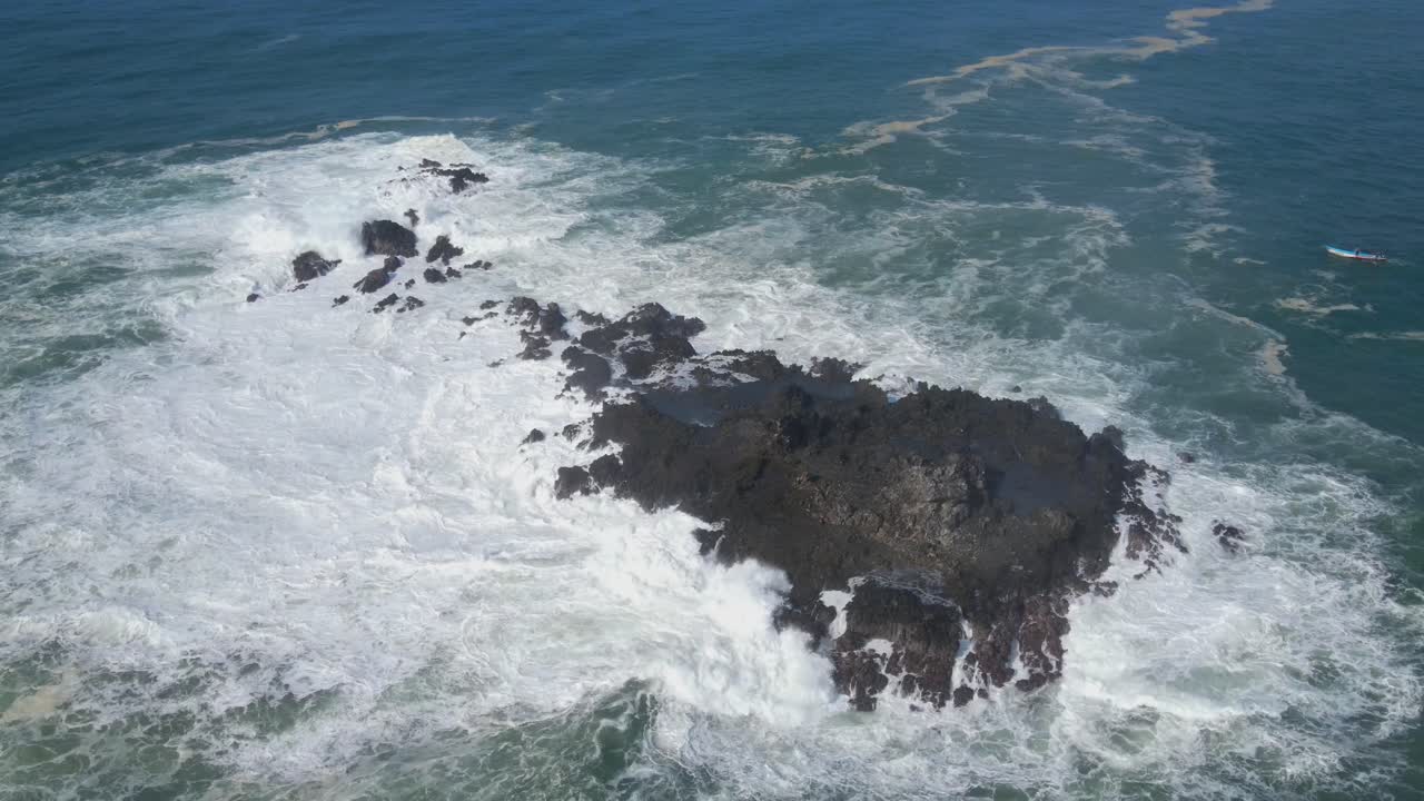 olas poderosas golpeando la roca de coral, órbita aérea