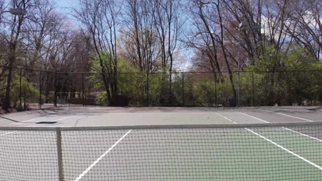 Drohnenaufnahmen-Auf-Einem-Tennisplatz,-Der-Parallel-Zum-Tennisnetz-Im-Freien-Fliegt