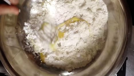 hand of chef whisking cake flour with egg yolk