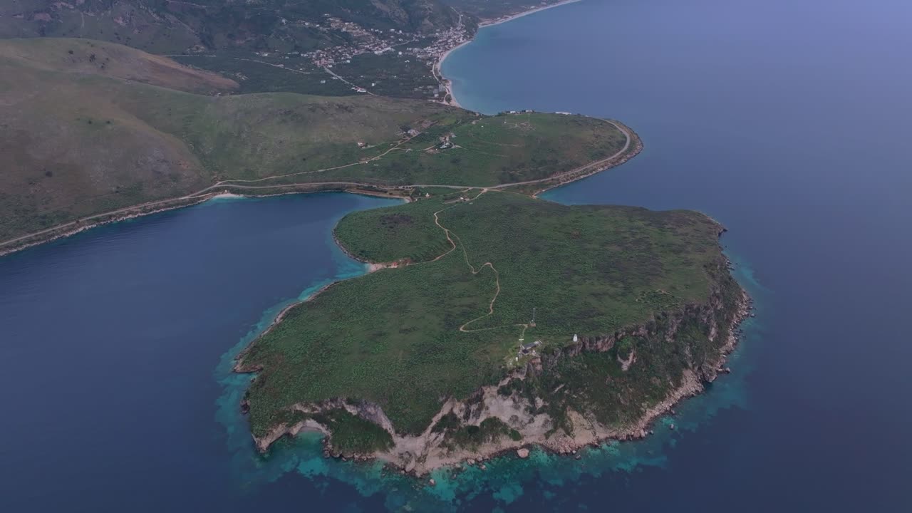 Porto Palermo'da sarp dağların ve sakin Akdeniz'in havadan görünümü.