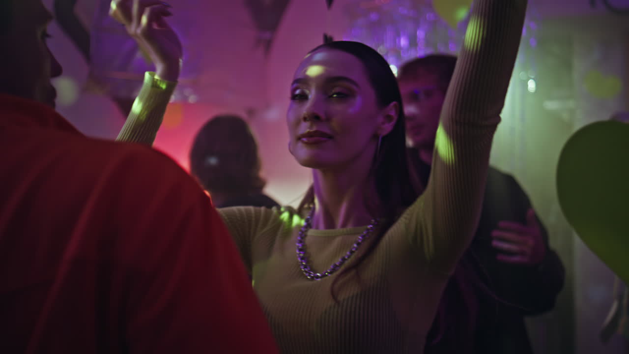 Festive clubbers moving dance floor in party atmosphere. Happy couple dancing