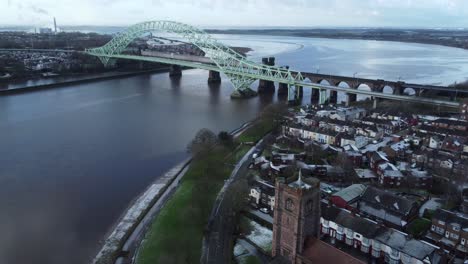 aerial descent to riverside small town jubilee bridge church rooftops neighbourhood north west england