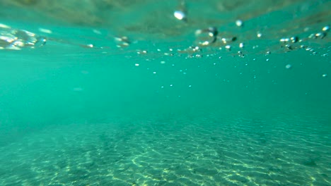 turquoise underwater texture with air bubbles and sunlight reflecting on river bottom, copy space