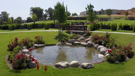 Low-close-up-aerial-shot-of-a-small-stream-in-a-decorated-private-estates-burial-grounds-at-a-mortuary-in-California