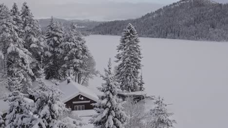 Vista-Idílica-De-Cabañas-Y-Montañas-Forestales-Densamente-Cubiertas-De-Nieve-En-Invierno