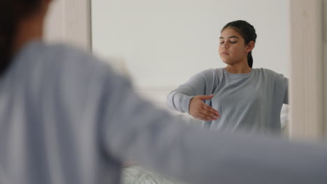 una adolescente feliz practicando ballet bailando en el dormitorio mirándose en el espejo ensayando divirtiéndose bailando la mañana del fin de semana con pijama