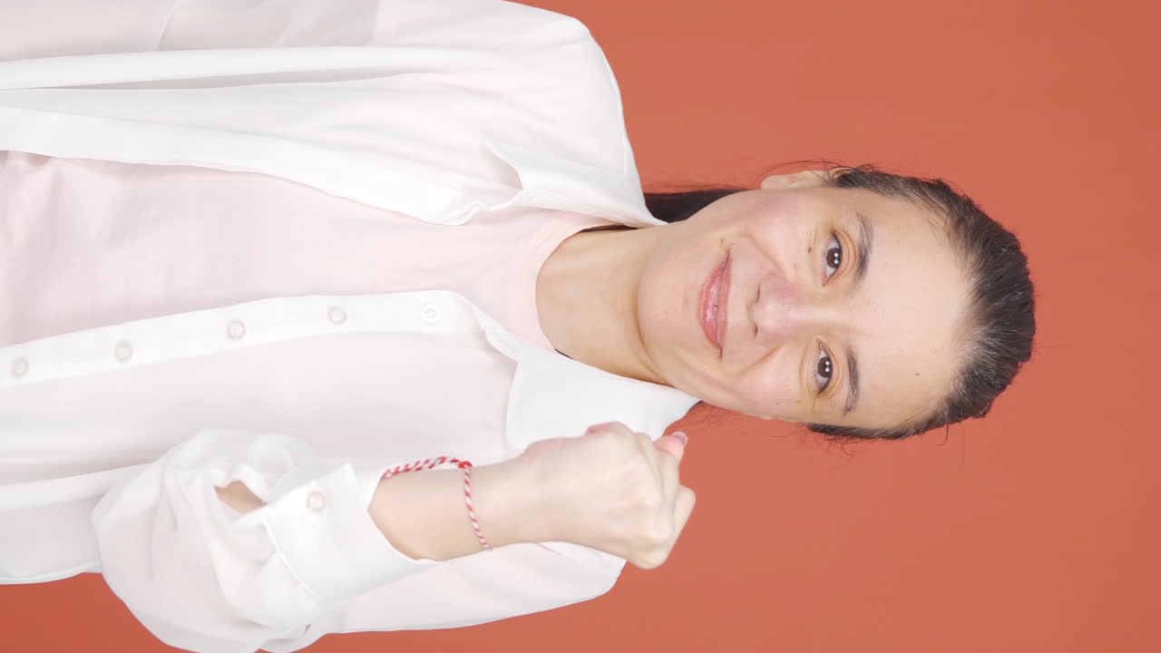 여성이 카메라를 바라보며 자신감을 표시하는 수직 비디오.