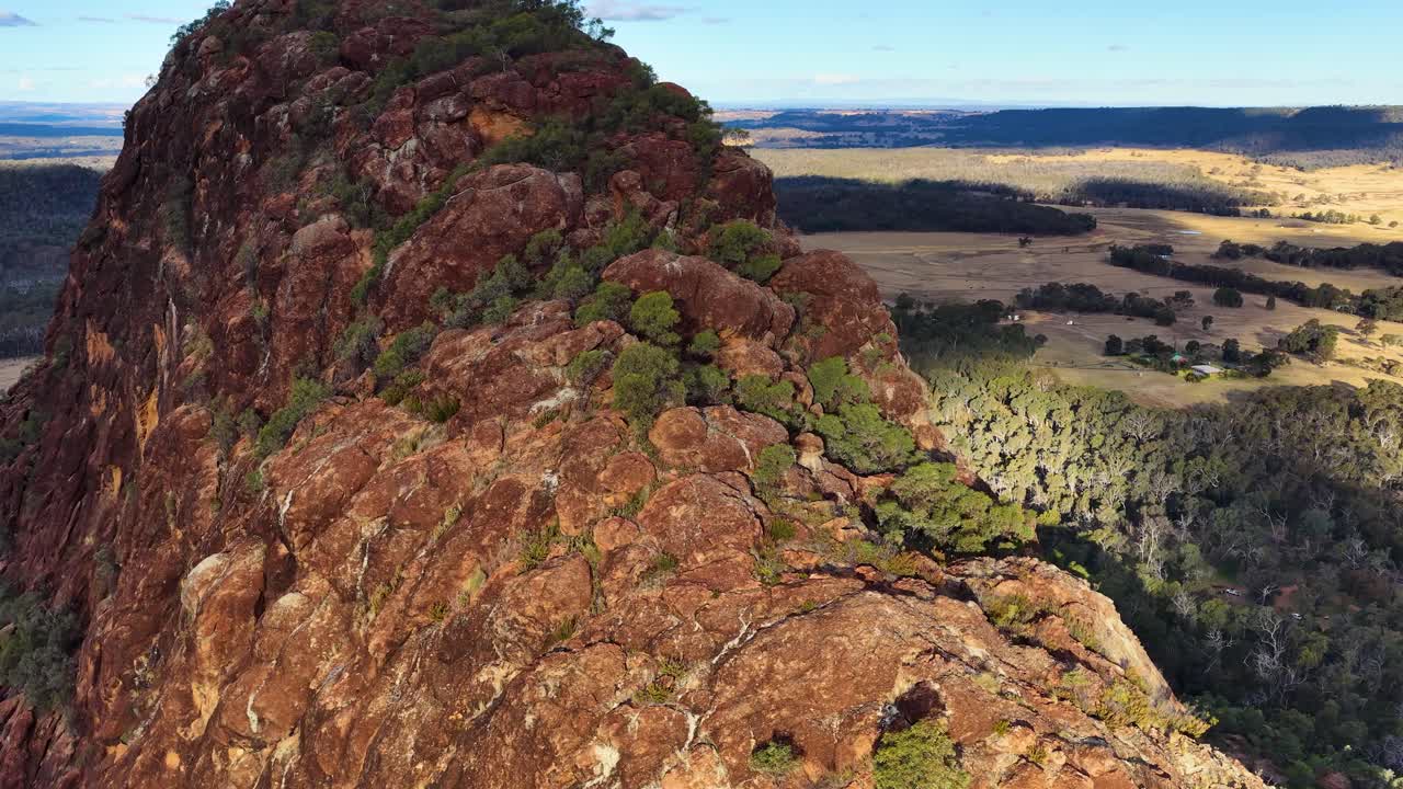 Drone glides above Timor Rock’s rugged volcanic ridge, revealing sweeping Australian outback at sunset