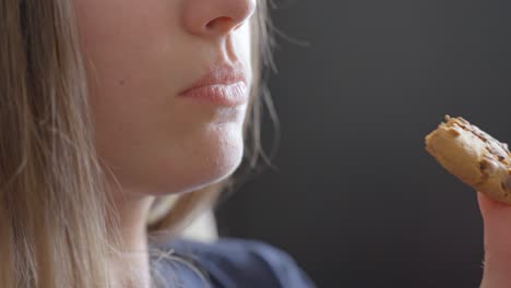 close-up of a young woman eating a snack in slow motion