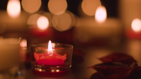 primer plano de velas rojas y blancas iluminadas románticamente ardiendo sobre un fondo negro con iluminación bokeh 4