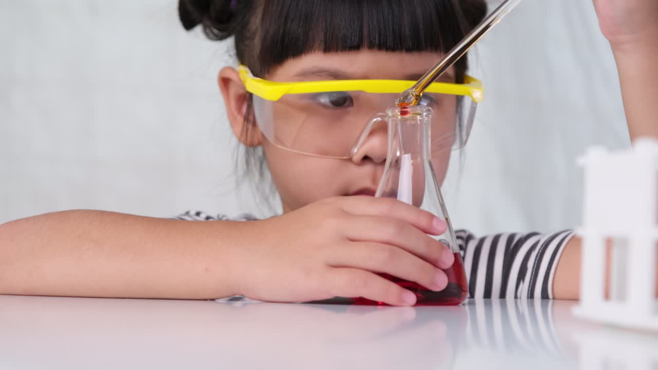 Anak-anak belajar dan melakukan percobaan sains di kelas. Gadis kecil bermain percobaan sains untuk sekolah di rumah. Percobaan sains yang mudah dan menyenangkan untuk anak-anak di rumah