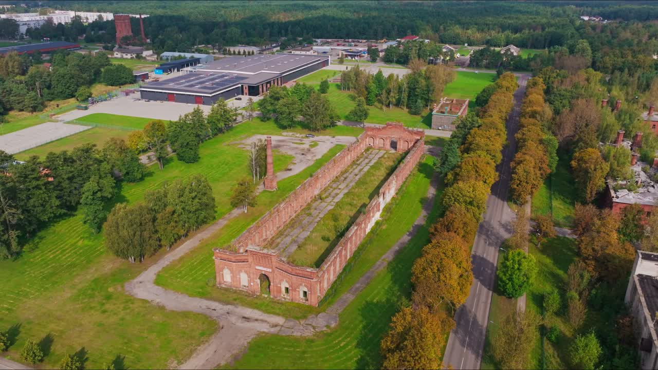 Powolne, kinowe ujęcie z drona ukazujące fasadę Maneżu Karosta we wrześniowym świetle.