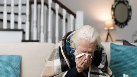 close up portrait of sick senior man sitting in a room, coughing and sneezing