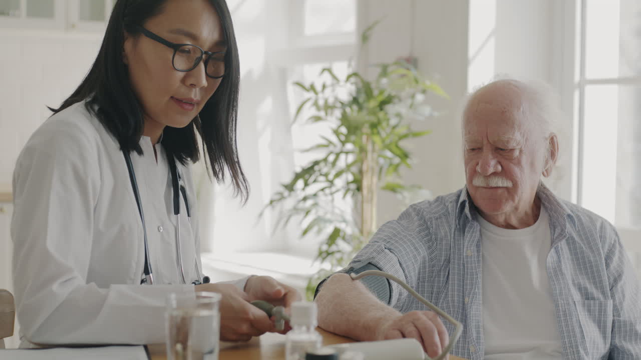 Doctor Examining Elderly Patient's Blood Pressure at Home