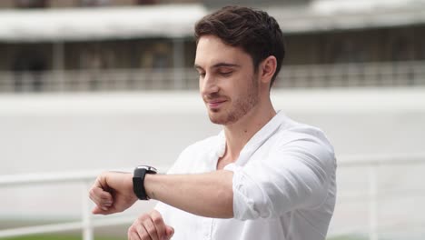 hombre de negocios comprobando la hora en el reloj inteligente. hombre usando el reloj inteligente después del trabajo