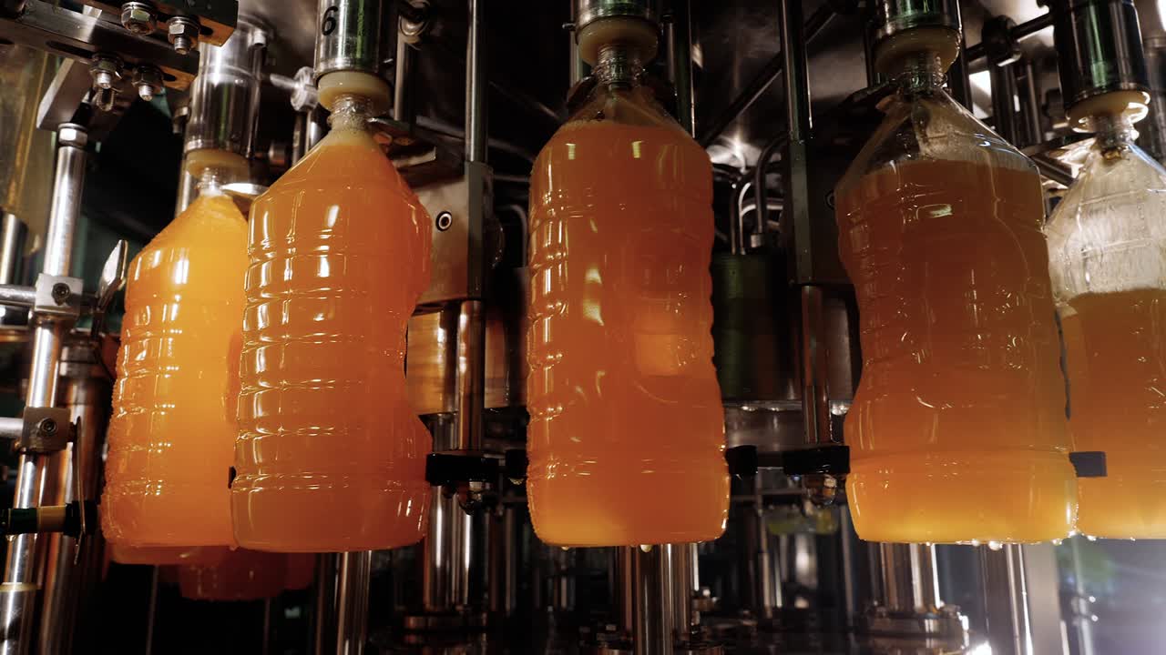 Automatic conveyor line of bottling natural orange citrus juices on plant.