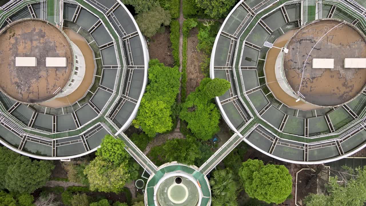 vista aérea de un avión no tripulado de una planta de tratamiento de aguas residuales con tanques de almacenamiento, árboles