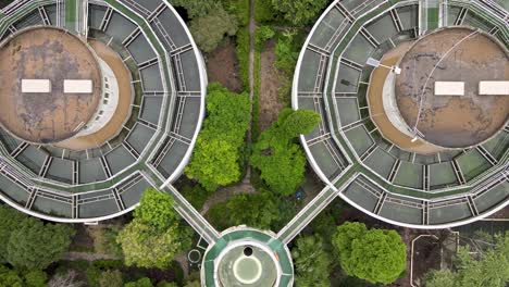drone aerial view of sewage water treatment plant with storage tanks, trees