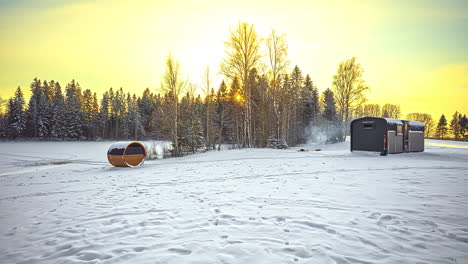 Time-lapse-shot-of-beautiful-snowy-landscape-with-cozy-wooden-house-and-tourist-making-campfire-outdoors-in-snow