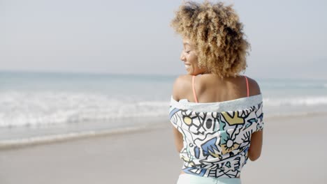 mujer joven positiva en la playa