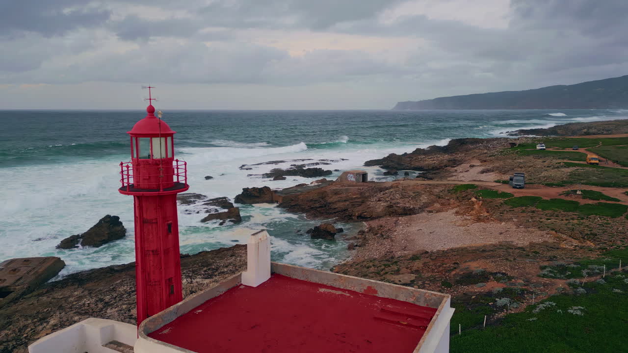 Lighthouse placed stormy seascape at cloudy evening. Waves crashing on cliffs