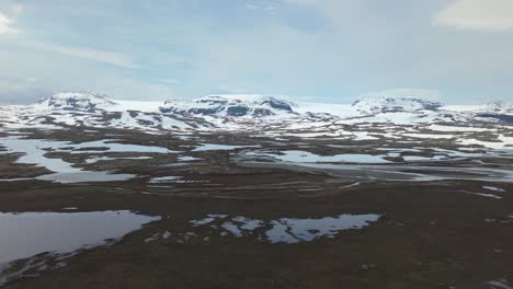 snow-covered mountain landscape near hardangerjokulen glacier in norway. - aerial pullback shot
