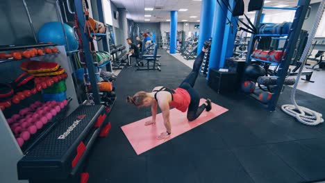Beautiful woman on mat at gym. Fit young woman doing workout exercise on mat
