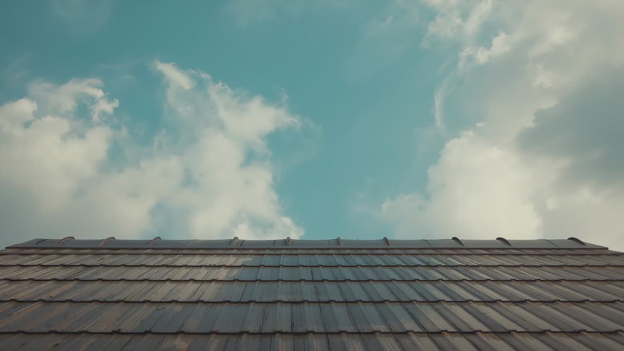 Camera capturing drifting clouds on suburban rooftop, with shadows moving across tiled roof edge