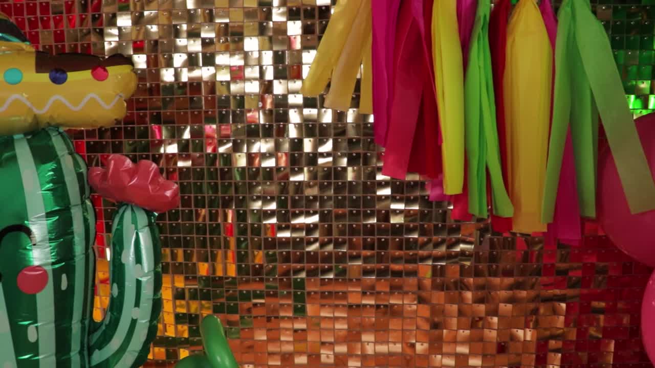 decoración mexicana con globos, cactus con sombrero y pared de brillo dorado, cinco de mayo