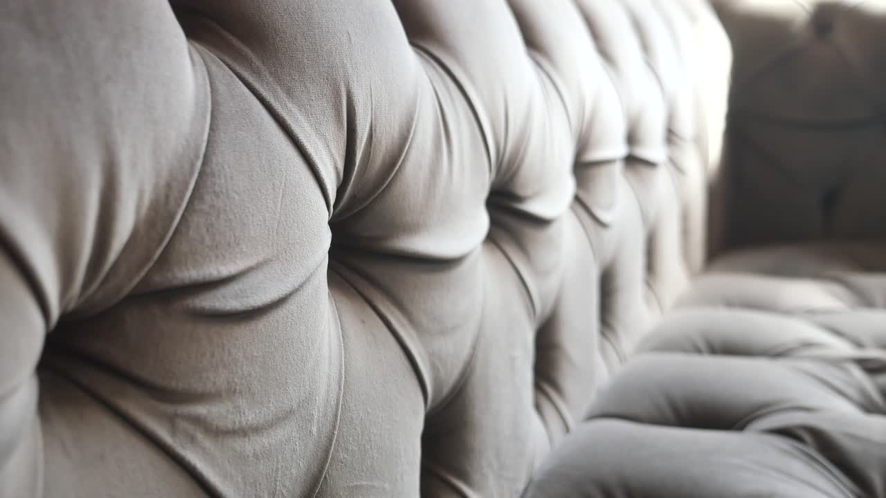 Close-up of a tufted gray velvet sofa