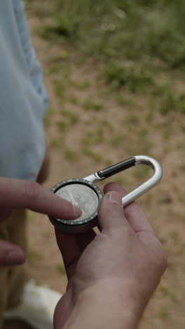 close-up of a person holding a compass outdoors