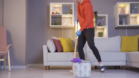 el hombre que limpia la casa mientras se divierte está bailando.