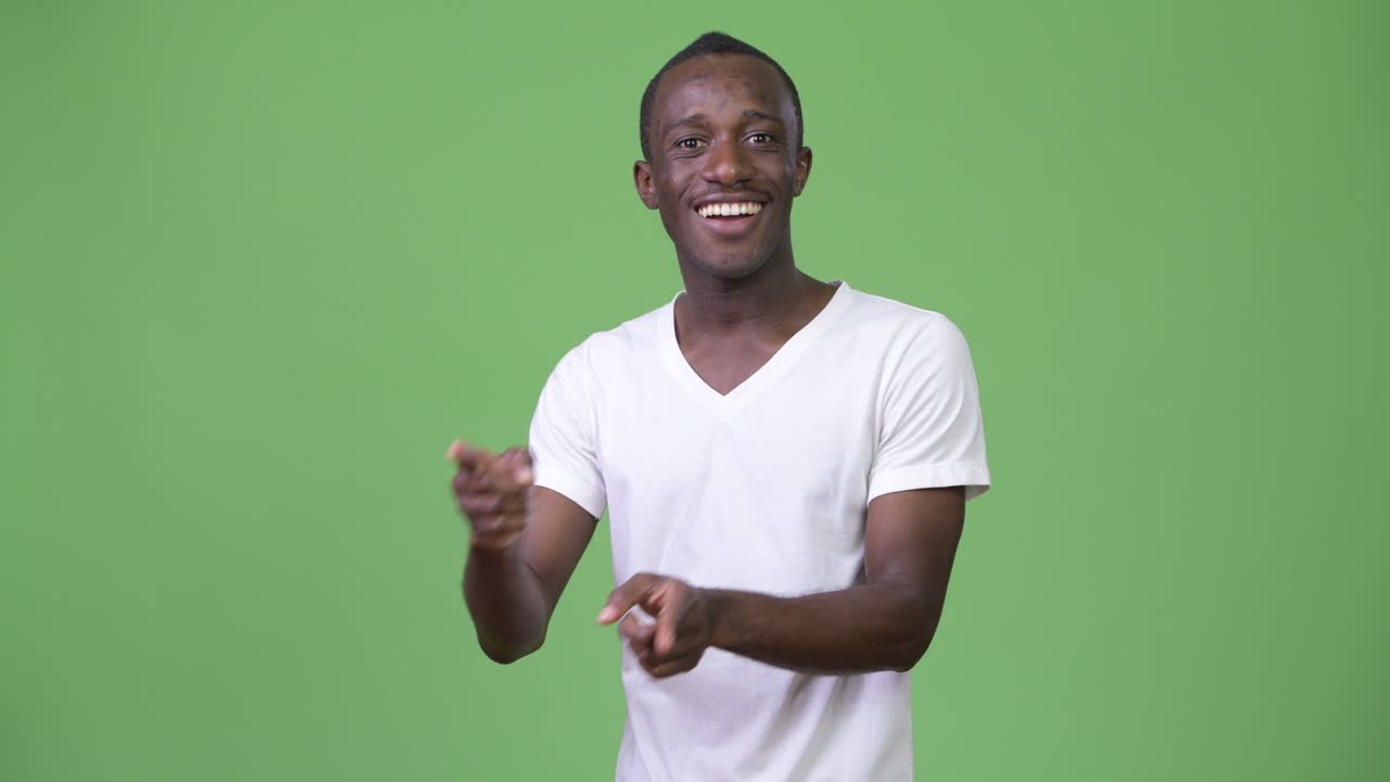 Young African man smiling while showing something