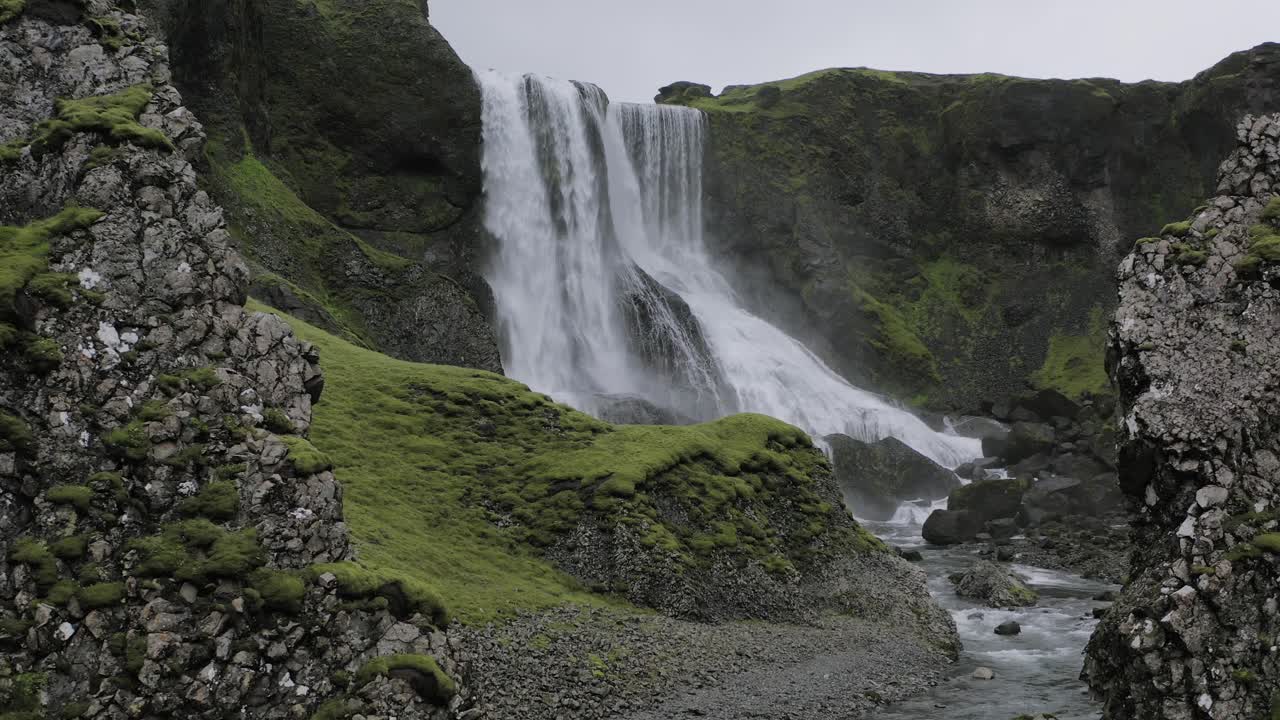 vista de la majestuosa cascada fagrifoss entre las rocas en el sureste de islandia - toma con zoom