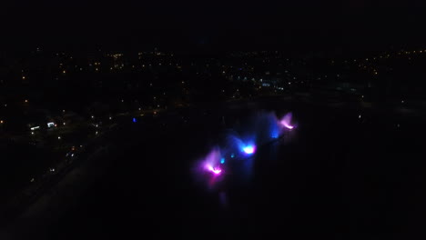 fountain with colorful illuminations at night. aerial shot of the magic fountain - lights,colors and music spectacle at night