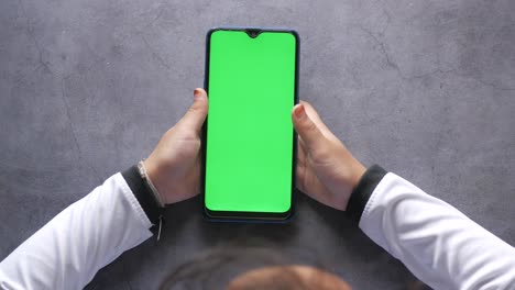 Child-hand-with-green-screen-chroma-key-smartphone-,