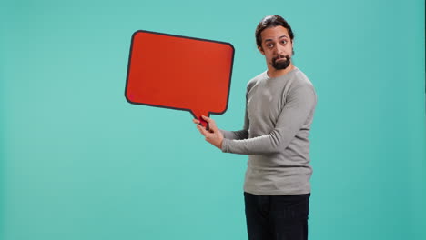 smiling man holding red speech bubble sign of empty copy space for message