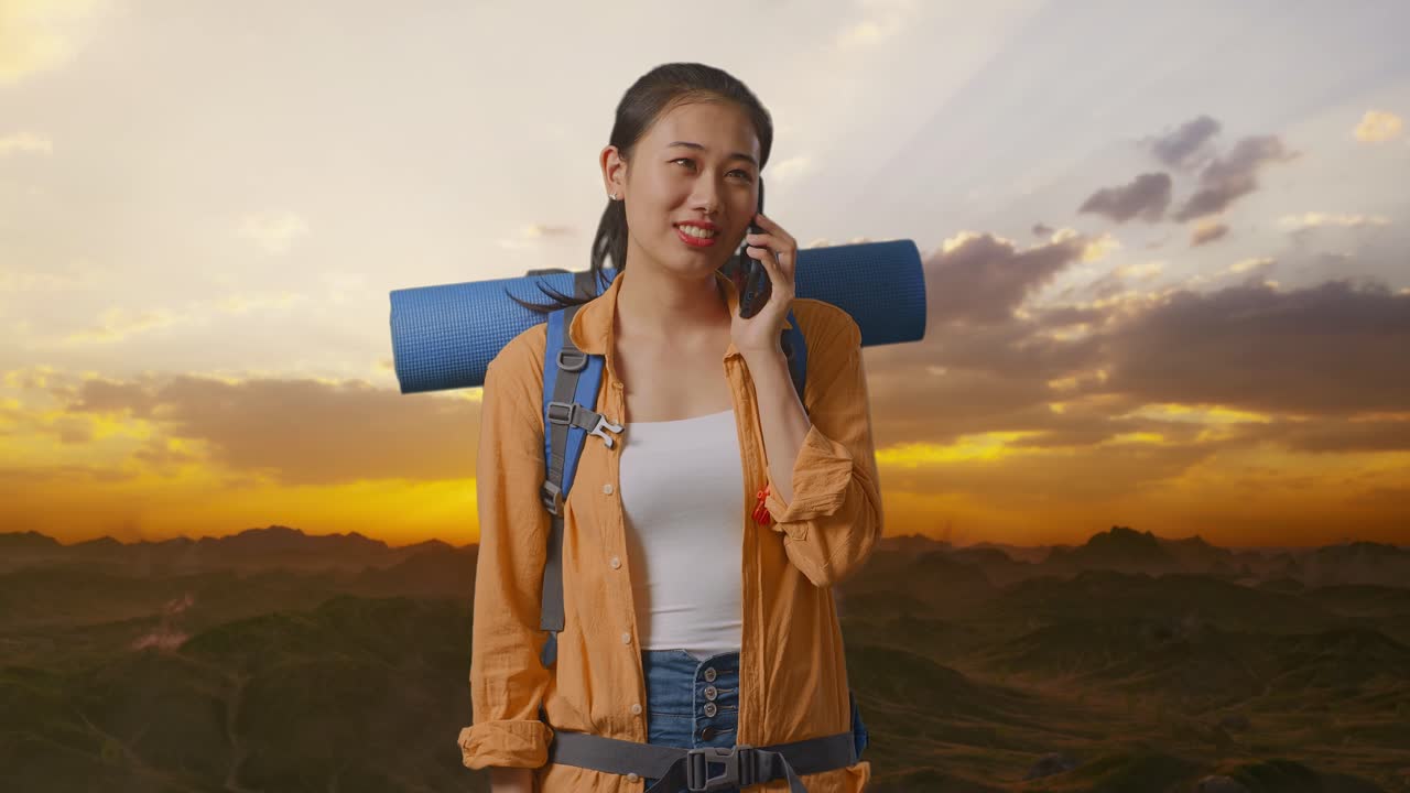 Woman on a Mountain Hike Talking on Phone at Sunset