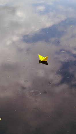 a paper boat floating on the river. origami ship sailing. vertical video
