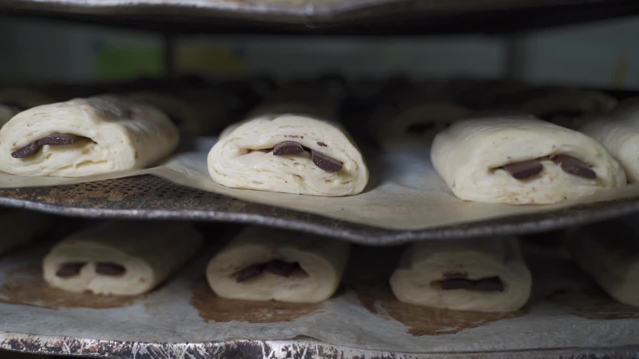 Dough pieces of chocolate crossangs on a tray in a bakery