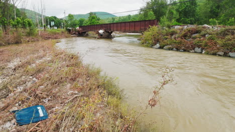 Drohnenansicht-Mit-Niedriger-Umlaufbahn:-Überschwemmungseffekte-In-Vermont-–-Hoher-Fluss-Und-Müll-Inmitten-Des-Flussufers