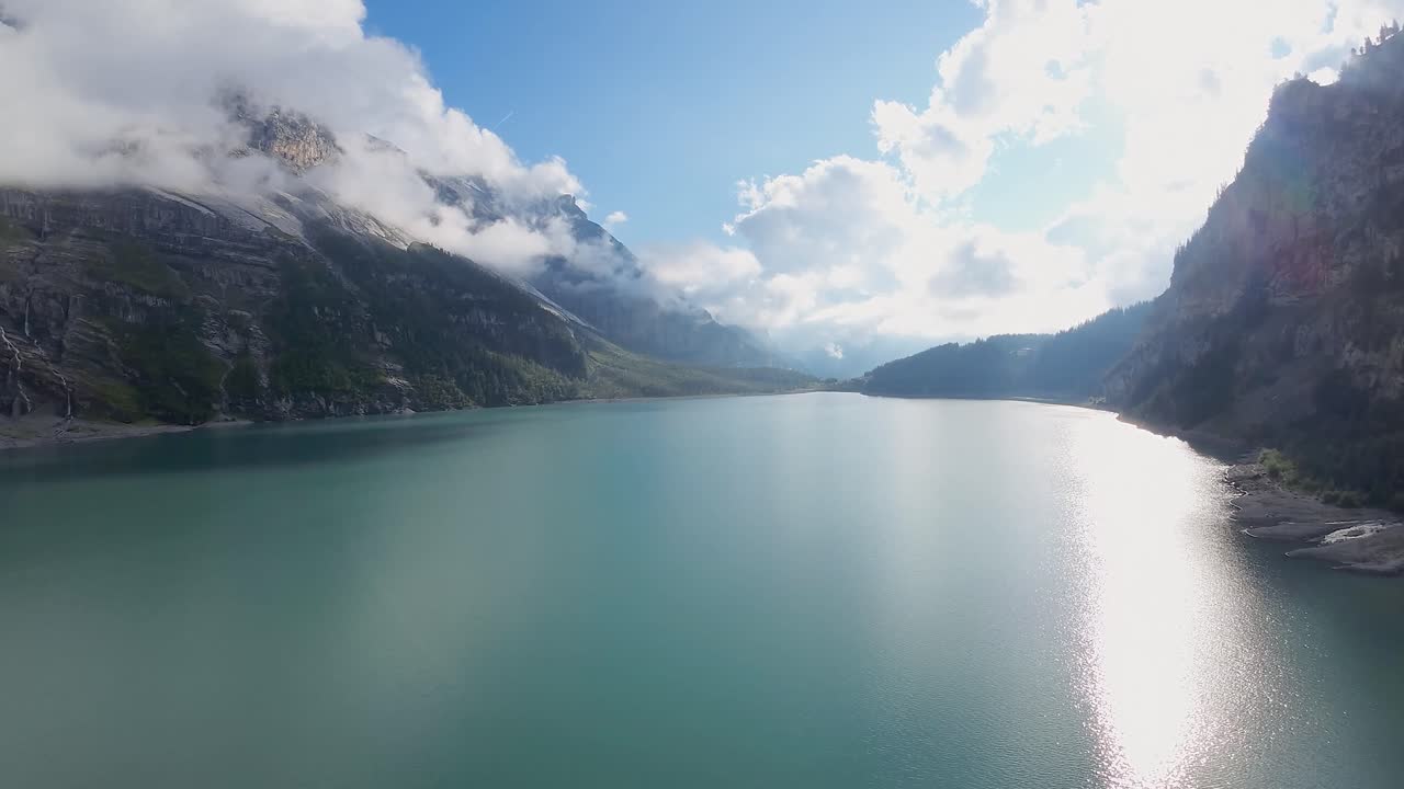 Aerial flight over a beautiful big Oeschinen lake on a mountain in Switzerland