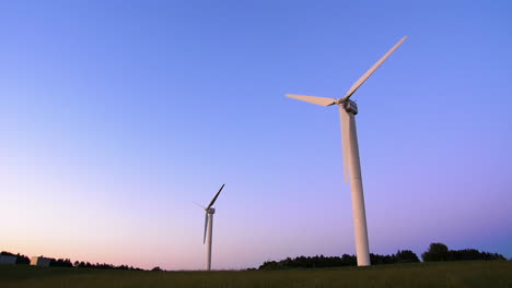 Windmil-turning-at-sunset,-wind-power-turbine-generating-clean-renewable-energy